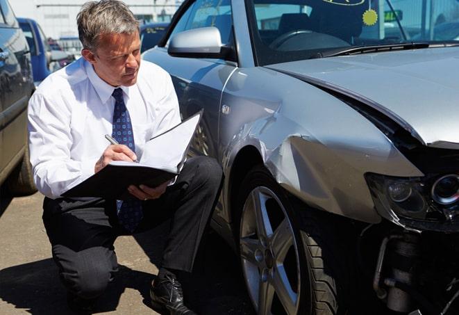 person holding car insurance card with car in background